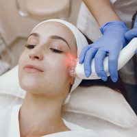 Cosmetologist use laser. Woman with cosmetologist. Lady in a beauty studio.